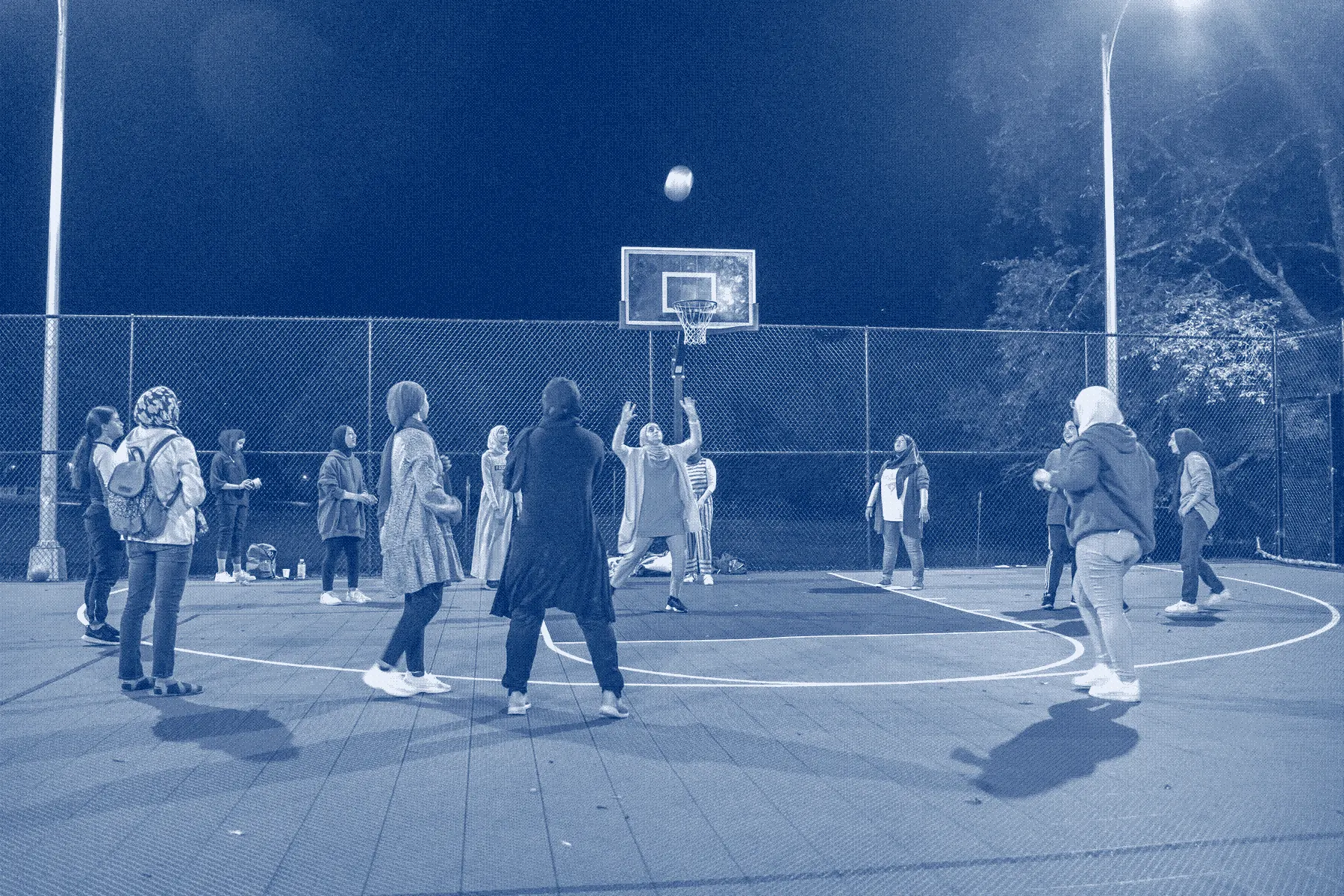 Young women playing basketball at night