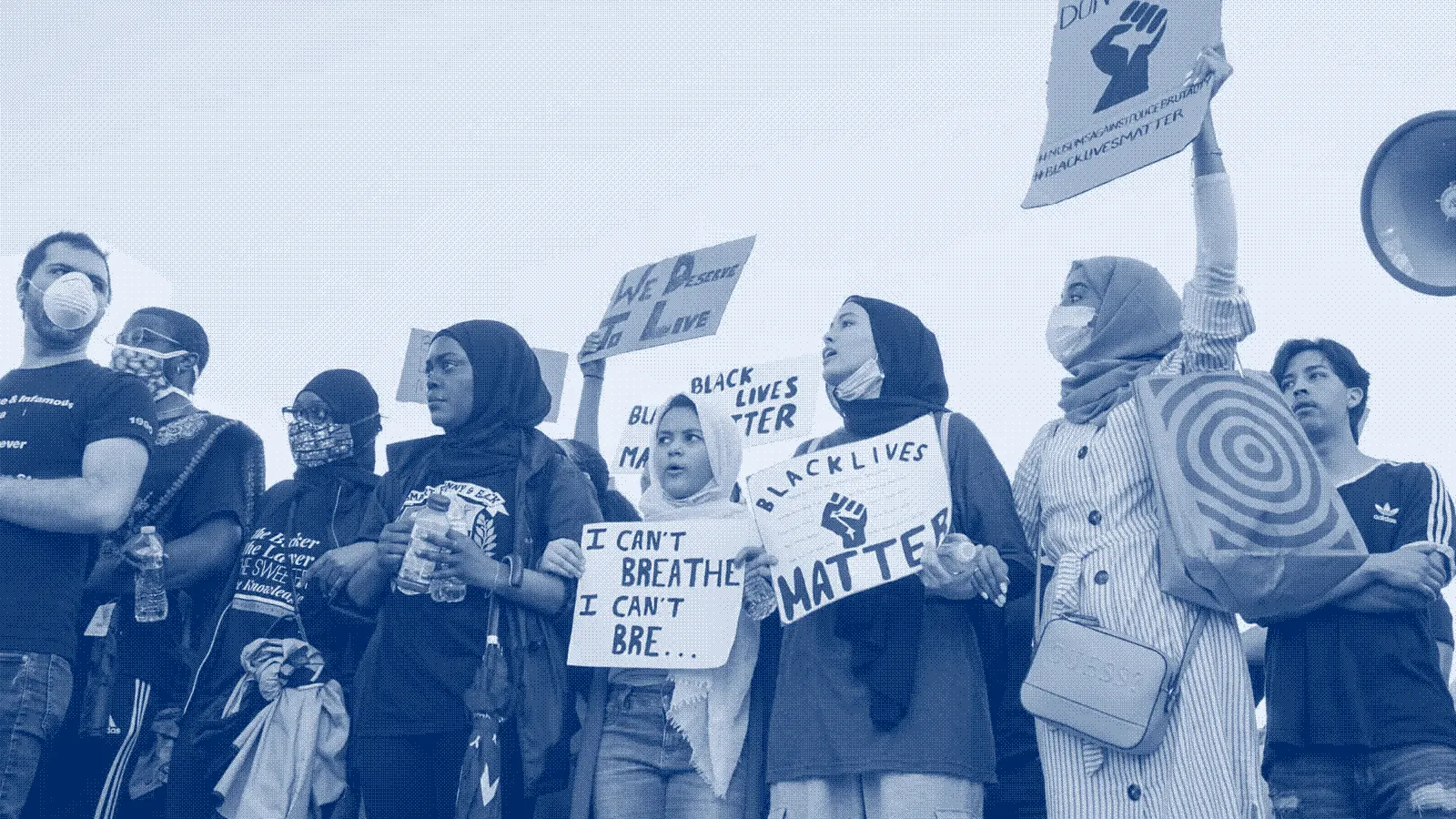 Young Muslim women at a rally holding signs